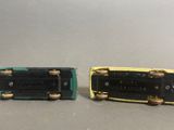 two miniature cars that are sitting next to each other