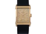 une image d'une montre-bracelet plaquée or avec un bracelet en cuir noir