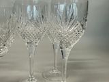 four wine glasses sitting next to each other on a table