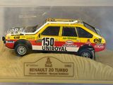 a toy car in a display case with sand on the ground