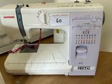 a white sewing machine sitting on a table next to a sewing machine