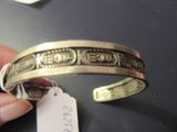 une personne tenant un bracelet en argent muni d'une étiquette