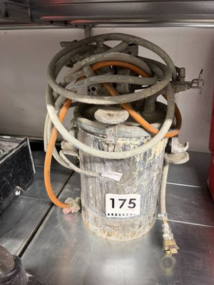 a bucket with a hose attached to it on a table