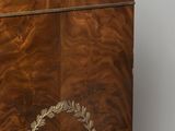 a wooden cabinet with a marble top and a wreath on the front