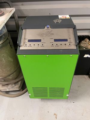 une machine posée par terre à côté d'une pile de fûts