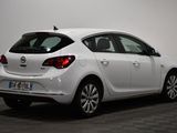 the back end of a white car parked in a room