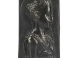 a black sculpture of a woman with a cross in her hand
