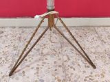 a vase that is sitting on a tripod on the floor