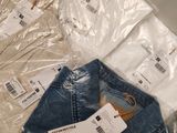 four pairs of jeans sitting on top of each other