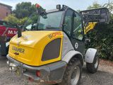 un engin de chantier jaune et noir garé sur un parking