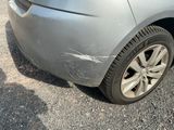 a car that has been dented and is parked on the side of the road