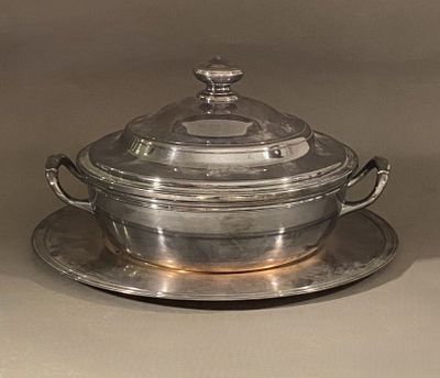 un plat en argent muni d'un couvercle en verre et un plat en argent sur lequel est posé un autre plat en argent