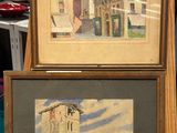two paintings of buildings are on display in a shop