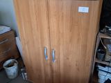 a cabinet in the corner of a room with a lot of clutter on it