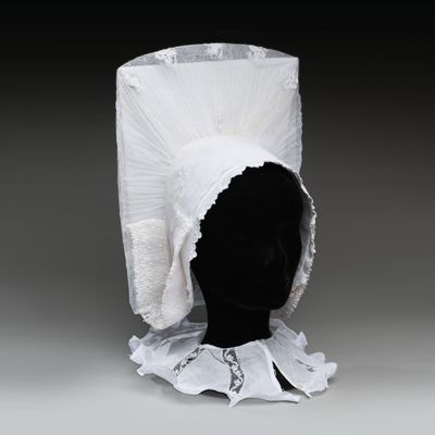 une tête de mannequin noire coiffée d'un chapeau blanc