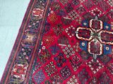 a red rug with a cross on it on the floor