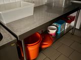 une cuisine avec un évier et deux seaux posés sur le plan de travail