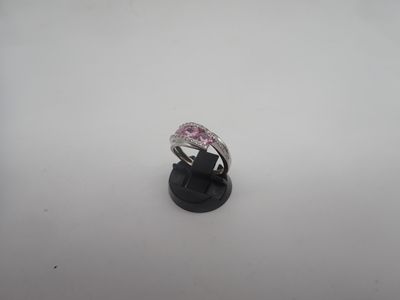 un gros plan d'une bague en diamant rose posée sur un socle noir