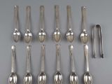 six silver spoons and a spoon rest on a table