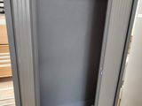 a metal cabinet with a sliding door in the middle of the room