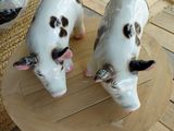 deux vaches en céramique posées sur un plateau en bois