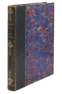 un vieux livre à la couverture bleue posé sur une surface blanche