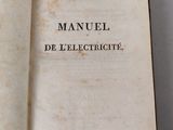 an open book on a table with the title manuel de l ' electtricite written in french