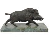 statue d'un sanglier en pleine course, posée sur un socle en marbre