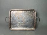 an old silver tray with handles and handles on a gray surface