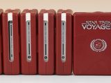 six téléphones portables rouges sont alignés en rangée sur une surface blanche
