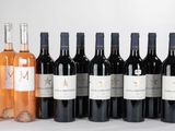 six bouteilles de vin sont alignées sur une table