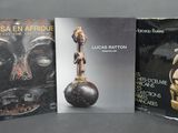 trois livres posés sur une table, devant lesquels se trouvent un vase et une statue