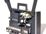 un vieux projecteur de cinéma posé sur une surface blanche