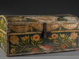 un vieux coffre en bois orné d'un motif floral