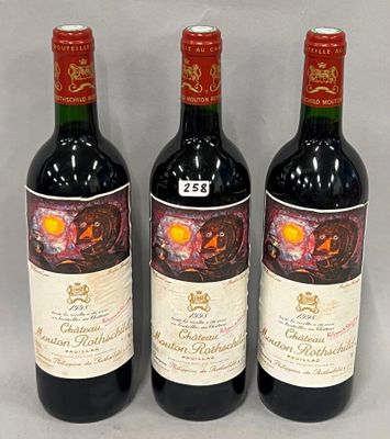 three bottles of red wine sitting next to each other on a table