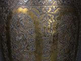 a large metal vase that is sitting on a table