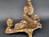 a statue of a bird sitting on top of a tree branch