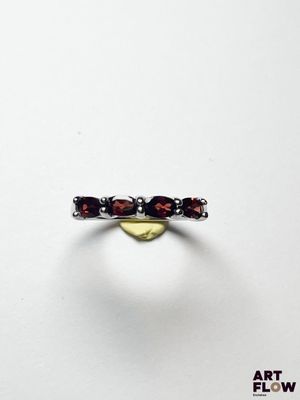 un gros plan d'une bague en argent sertie de grenats