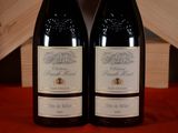 two bottles of wine sitting next to each other on a table