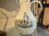 a vase with a picture of a dog on it sitting on a glass shelf