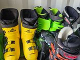several pairs of ski boots are lined up on the floor