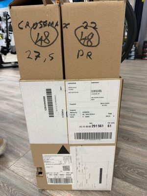 two boxes with stickers on them sitting on a wooden floor