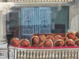 a display of oranges in a glass case in front of a building