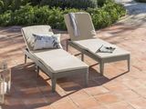 two lounge chairs and a table on the patio