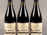 trois bouteilles de vin posées l'une à côté de l'autre sur une table