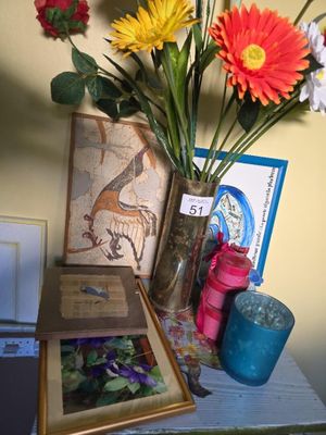 a vase of flowers on a table next to a picture