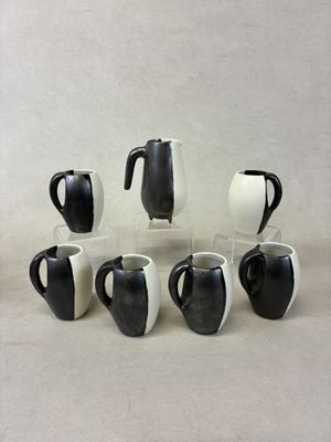 several black and white coffee mugs are arranged in a circle