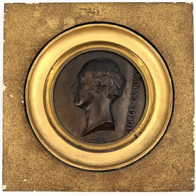 an image of a bronze medallion of a man in profile