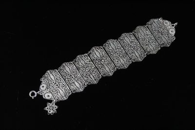 un vieux bracelet en argent orné de motifs complexes sur fond noir