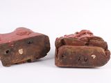 two pieces of red clay sitting next to each other on top of a white surface